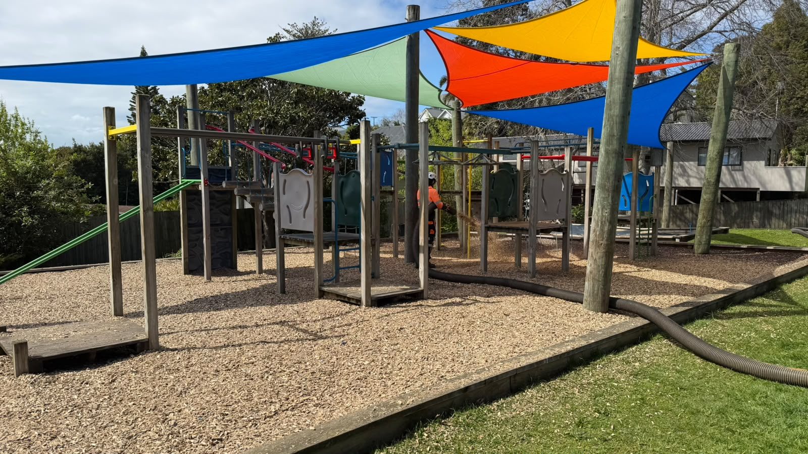 Reharvest crew topping up Cushionfall® around play equipment using the specialist pump hose